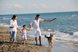 happy family playing with dog on beach happy family playing with dog on beach