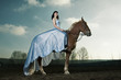 Beautiful woman riding on a brown horse