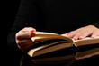 Open book in hands on black background Open book in hands on black background