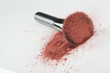 a blush brush, with pink loose blush