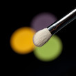 detail of a eye-shadow brush above 3 eye-shadows