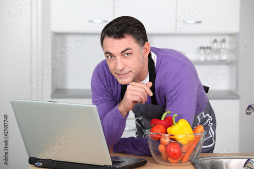 Photo: Man in kitchen with laptop computer Man in kitchen with laptop computer