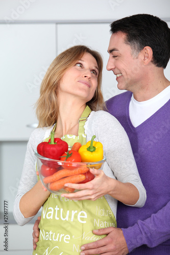 Photo: Couple in kitchen with bowl of vegetables Couple in kitchen with bowl of vegetables