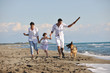 happy family playing with dog on beach happy family playing with dog on beach