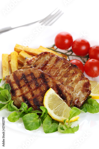 Photo: Closeup of grilled steak with lemon on white isolated background Closeup of grilled steak with lemon on white isolated background