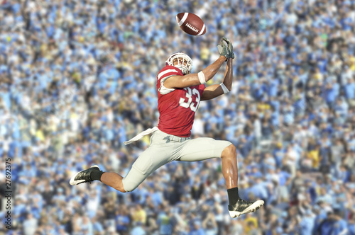 Foto: football player catches ball in midair football player catches ball in midair