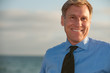 Business man on the beach in blue shirt and tie