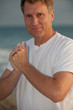attractive man on beach wearing white tshirt