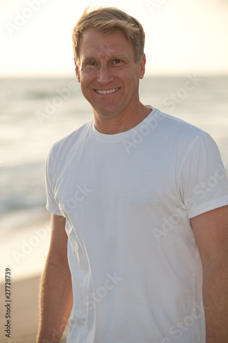 Photo: attractive blond man in white tshirt on the beach attractive blond man in white tshirt on the beach