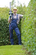 Gartenarbeit, Mann schneidet Hecke