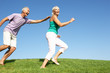 Senior couple running through field