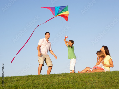 Photo: Young family, parents with children, playing in a field Young family, parents with children, playing in a field