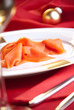 geräucherter Lachs zu Weihnachten auf rot dekoriertem Tisch geräucherter Lachs zu Weihnachten auf rot dekoriertem Tisch