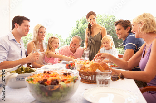 Photo: A family, with parents, children and grandparents, enjoy a picni A family, with parents, children and grandparents, enjoy a picni