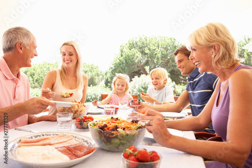 Photo: Extended family, parents, grandparents and children, eating outd Extended family, parents, grandparents and children, eating outd