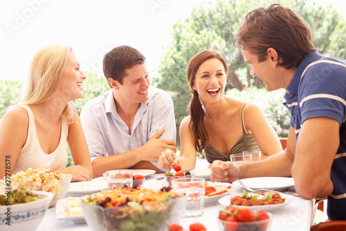 Photo: Two young couples eating outdoors Two young couples eating outdoors