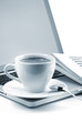 Hot cappuccino cup on laptop and newspaper Hot cappuccino cup on laptop and newspaper