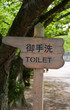 Wooden finger style sign pointing to toilets