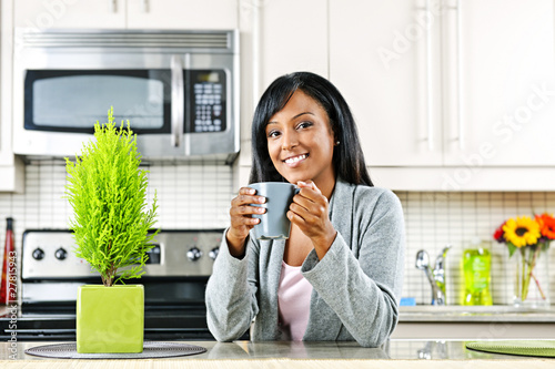 Photo: Woman in kitchen with coffee cup Woman in kitchen with coffee cup