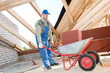 worker roofer and wheel barrow with clay tile