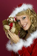 Frau mit Santa Claus Kleidung und Teddy.