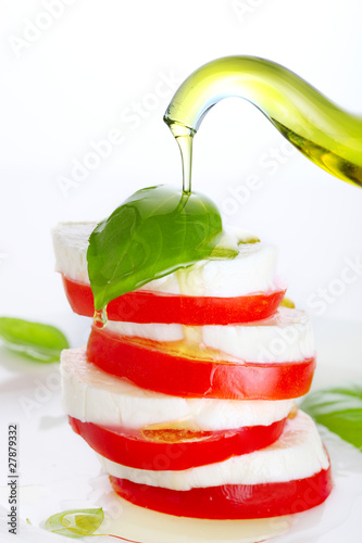 Photo: Fresh salad with mozzarella, tomato and basil with olive oil pou Fresh salad with mozzarella, tomato and basil with olive oil pou
