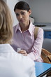 Patient in doctor's office holding bottle of pills