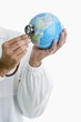 Doctor's hands holding stethoscope to globe
