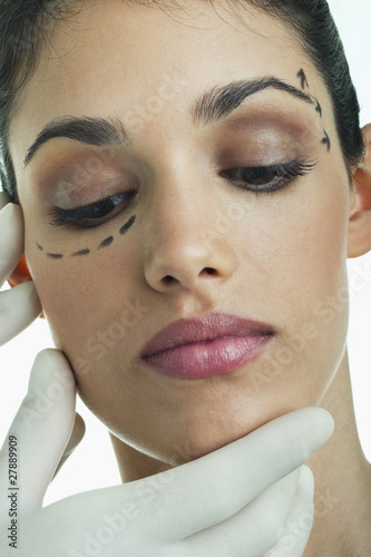 Photo: Hands with surgical gloves on patient's face with distance marker Hands with surgical gloves on patient's face with distance marker