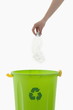 Young woman's arm throwing plastic bottle in the recycling bin