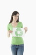 Young woman holding recycling symbol drawing