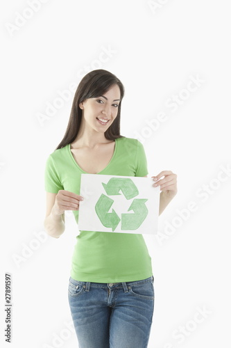 Photo: Young woman holding recycling symbol drawing Young woman holding recycling symbol drawing