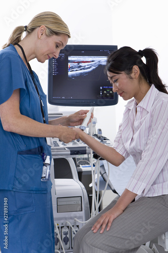 Photo: Technician using ultrasound treatment on patients wrist Technician using ultrasound treatment on patients wrist