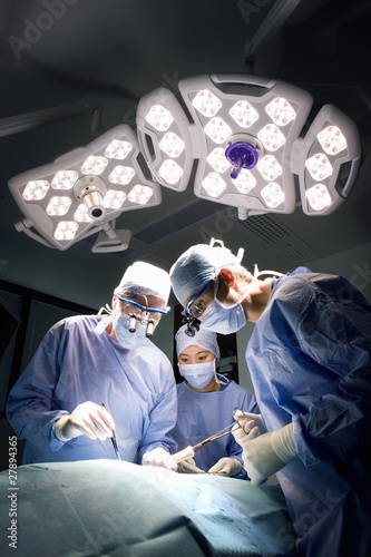 Photo: Concentrating surgeons performing operation in operating room Concentrating surgeons performing operation in operating room