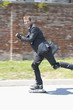 Businessman in suit inline skating