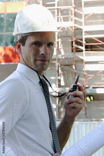 Photo: Man with hardhat and walky talky radio at construction site Man with hardhat and walky talky radio at construction site