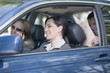 Woman driving car with two other people