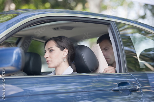 Photo: Woman driving car with two other people Woman driving car with two other people