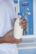 Closeup of man's hands holding milk bottle at cooler