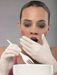 Photo: Portrait of shocked young woman eating, studio shot Portrait of shocked young woman eating, studio shot