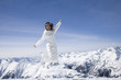 Young woman in ski gear jumping in midair in the mountains