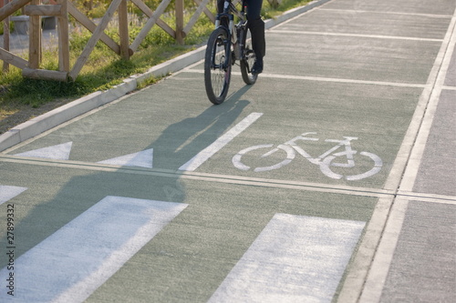 Photo: Partial view of man riding bicycle in bicycle lane Partial view of man riding bicycle in bicycle lane