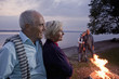 Two senior couples standing beside a campfire