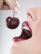 A woman eating a cherry, close-up
