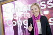 Photo: A portrait of a businesswoman standing outside a congress centre wearing a pink scarf A portrait of a businesswoman standing outside a congress centre wearing a pink scarf