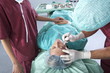Surgeon with scalpel on patient's face.