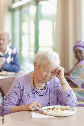 Photo: A senior woman having lunch looking sad A senior woman having lunch looking sad