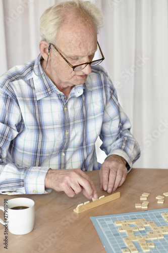 Photo: A senior man playing a board game A senior man playing a board game