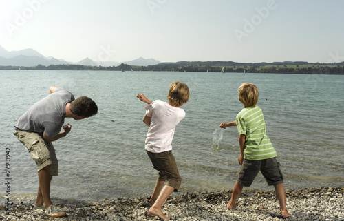 Photo: Three children skimming stones Three children skimming stones