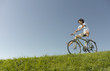 A man freewheeling downhill on a bicycle in summertime